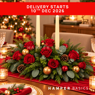 Christmas table centrepiece with red roses, festive foliages and ornaments