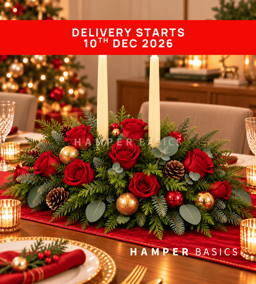 Christmas table centrepiece with red roses, festive foliages and ornaments