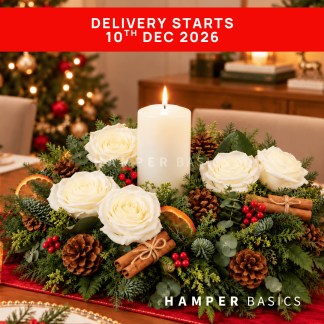 Christmas table centrepiece with white roses, dried orange slices, pine cones, cinnamon sticks, fillers, foliages and candle