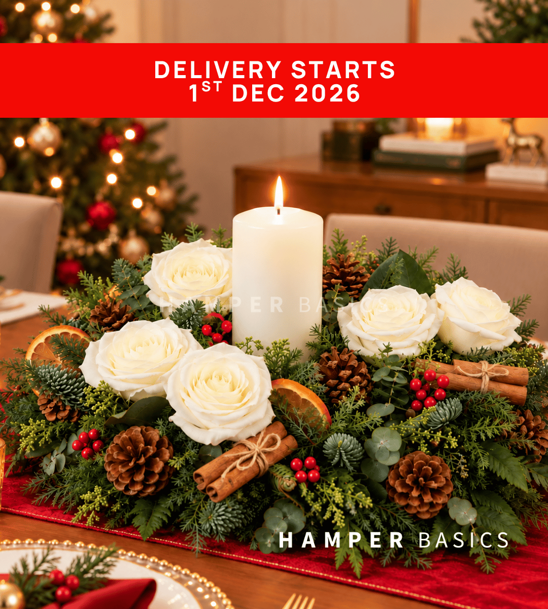Christmas table centrepiece with white roses, dried orange slices, pine cones, cinnamon sticks, fillers, foliages and candle