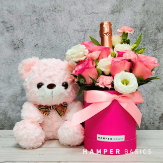 Pink flower bloom box with teddy bear and wine