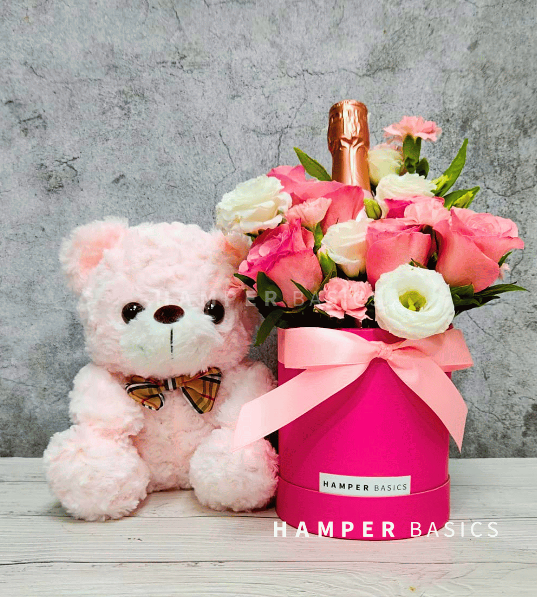 Pink flower bloom box with teddy bear and wine